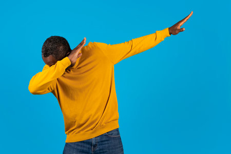 Cool african american man in casual showing moves on blueの写真素材