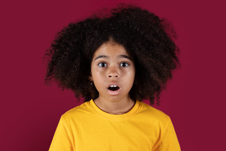 Portrait of shocked black girl on colorful backgroundの写真素材