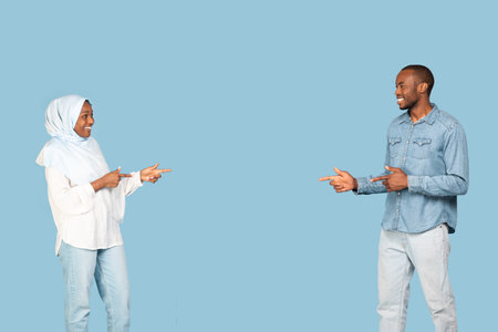African Muslim Couple Pointing Fingers Choosing Each Other, Blue Background