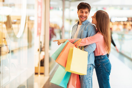 Buyers Couple Shopping Pointing Finger At Shop Window In Hypermarketの写真素材
