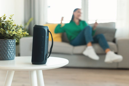 Music Speaker Standing On Table While Woman Listening Music Indoors