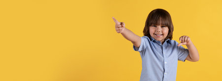 Great offer. Adorable little boy pointing aside and smiling, gesturing over orange background,...