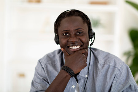 Portrait Of Happy Handsome Young Black Man In Headset Smiling At Cameraの写真素材
