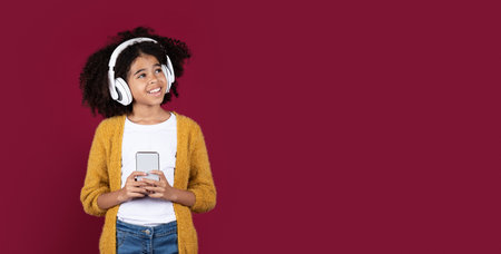 Cute black girl teenager using headphones and cell phone