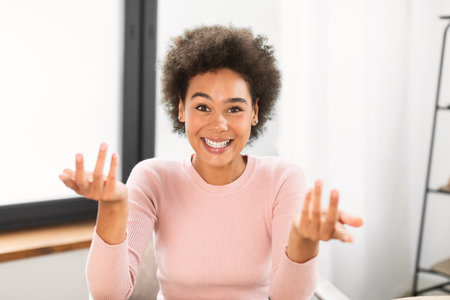 Portrait of happy millennial african american woman has video call, gesturing, talking in bright...