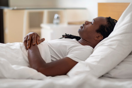 Side View Of Young Black Male Sleeping In Bed At Homeの写真素材