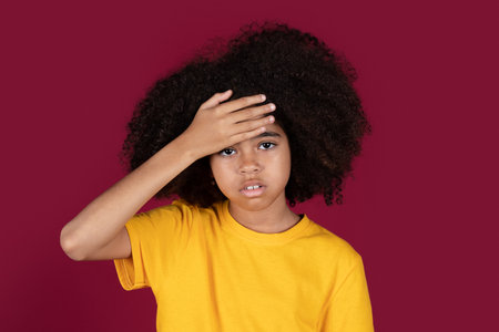 Embarrassed african american girl holding hand on foreheadの写真素材