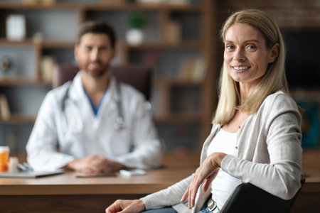 Portrait Of Happy Young Female Patient Sitting At Doctors Officeの写真素材