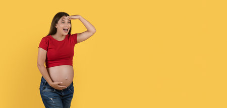 Curious Pregnant Woman Keeping Hand Near Forehead And Looking At Copy Spaceの写真素材