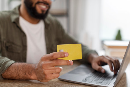 Online payment concept. Closeup shot of man with laptop and credit card in hands shopping online, croppedの写真素材