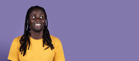 Smiling black guy looking at copy space on purple