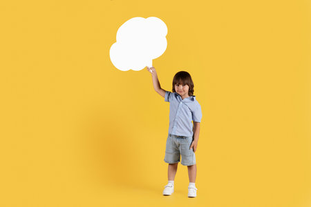 Kids opinion matters. Studio shot of cute little boy holding speech bubble and looking at camera, empty space for textの写真素材