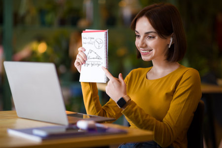 Cheerful young woman manager have business meeting online, cafe interiorの写真素材