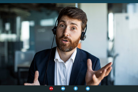 Businessman making video call from office, wearing headphones and talking to webcamera, pov screenshotの写真素材