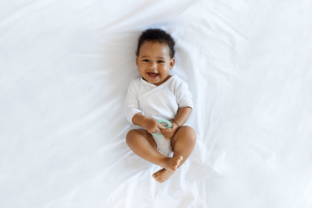Child Care. Top View Of Adorable Black Infant Boy Relaxing On Bedの写真素材