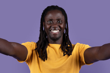 Closeup of happy handsome black guy taking selfie on blue