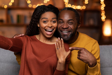 Happy black couple got engaged, taking selfie togetherの写真素材