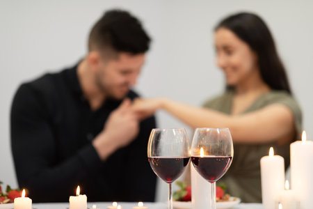 Selective focus on glasses with red wine over bonding coupleの写真素材