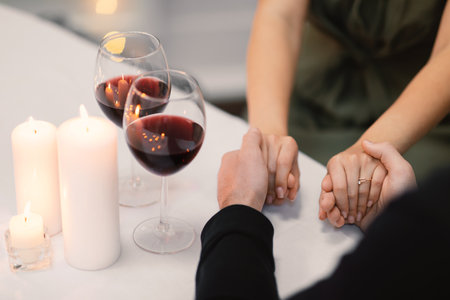 Cropped of loving couple holding hands while have dateの写真素材