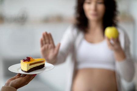 Healthy Eating During Pregnancy. Young Pregnant Female Refusing Cake And Choosing Appleの写真素材