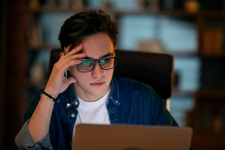Young businessman working overtime alone in an officeの写真素材