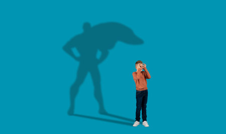 Shadow of super hero over dreamy ginger guy schoolerの写真素材