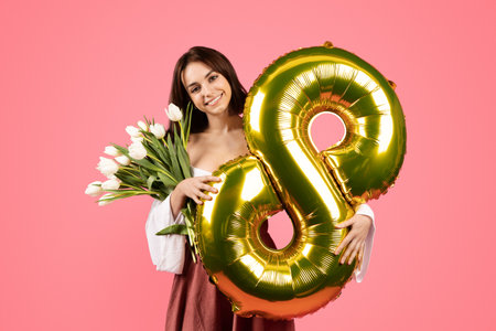 Cheerful young european lady hold bouquet of flowers and balloon number 8, rejoices spring holidayの写真素材