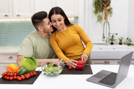 Cheerful young couple looking for nice recipe on Internetの写真素材