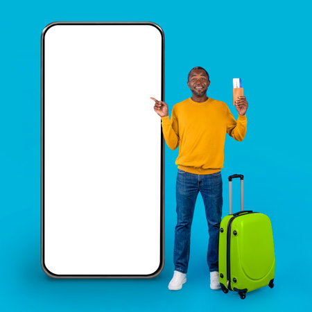 African american man traveller pointing at huge smatphone, mockupの写真素材