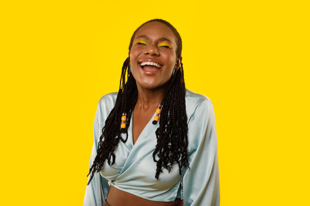 Cheerful African American Lady Laughing Out Loud Over Yellow Backgroundの写真素材