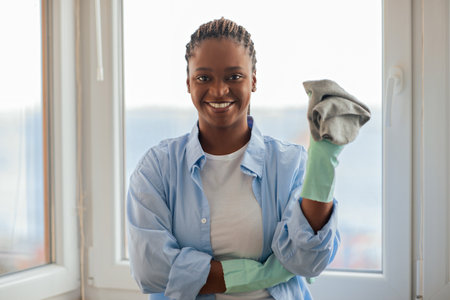 Positive pretty african american lady holding cleaning cloth and smilingの写真素材