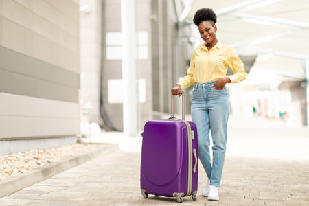 Cheerful African American Female Posing With Travel Suitcase At Airportの写真素材