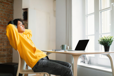 Chinese Teenager Boy At Laptop Relaxing Listening Music At Home