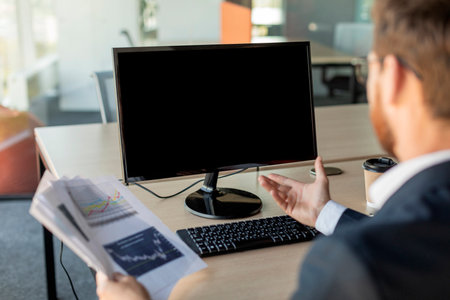 Businessman having video call, talking to computer webcam and gesturing, discuss financial documents at online meetingの写真素材