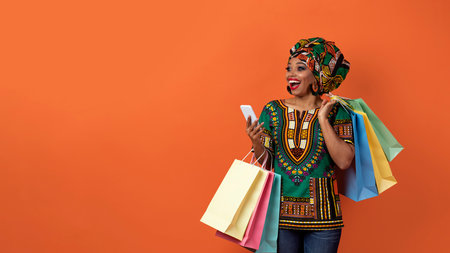 Emotional black woman in african costume shopping online, copy spaceの写真素材