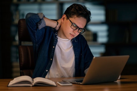 Feeling exhausted. Frustrated young handsome man looking exhausted while sitting at his working...