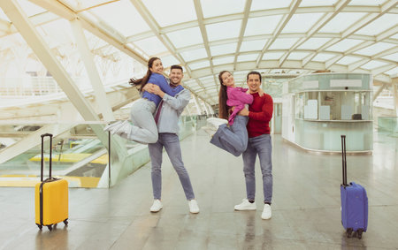 Two Joyful Couples Celebrating Vacation Posing Having Fun In Airportの写真素材