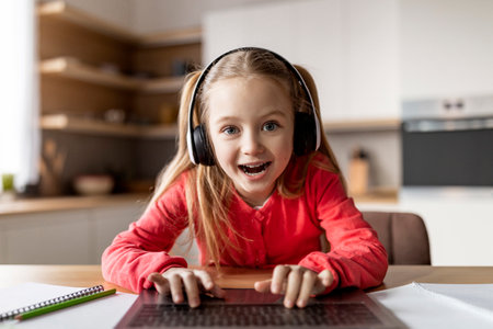 Pov Shot Of Cute Little Girl In Headset Using Laptop At Homeの写真素材
