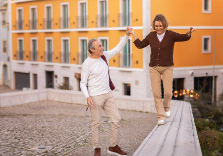 Joyful Mature Tourists Couple Walking Holding Hands Having Fun Outdoorsの写真素材