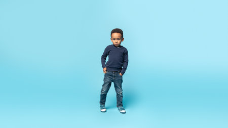 African american child boy in casual wear standing with serious expression, holding hands in pocket, full lengthの写真素材