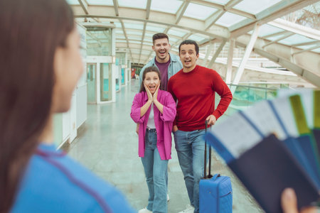 Female Showing Boarding Passes To Friends Traveling Together In Airport