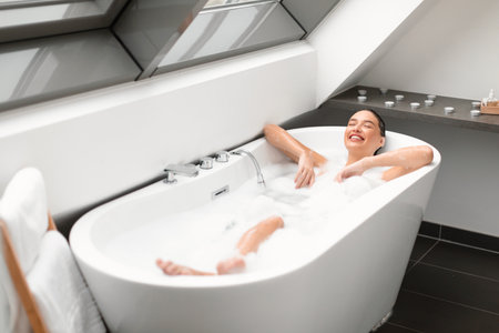 Woman Relaxing Taking Bath Lying In Water In Modern Bathroomの写真素材