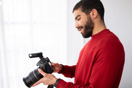 professional male photographer with digital photo camera in photo studio