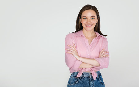 Cheerful pretty young woman posing on studio background, copy spaceの写真素材