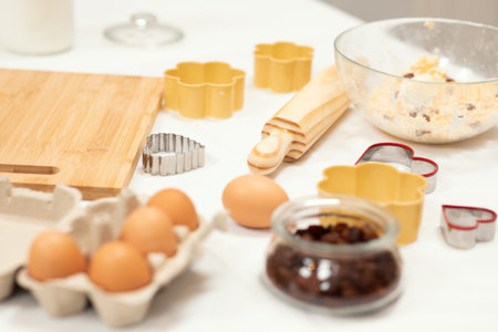 Dough for cookies with flour, butter and eggs, wooden rolling pin on table in kitchen interior, close upの写真素材