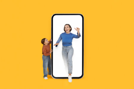 Daughter Looking At Mom Walking Out Of Big Blank Smartphoneの写真素材