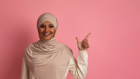 Nice Offer. Smiling Islamic Woman In Hijab Pointing Aside At Copy Spaceの写真素材