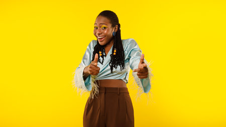 Excited African Lady Pointing Fingers At Camera Over Yellow Backgroundの写真素材