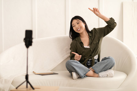 Cute asian female vlogger dancing, recording content for followersの写真素材