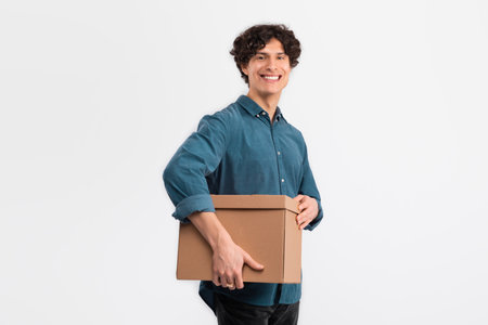 Cheerful Man Holding Cardboard Box Parcel Standing Over White Backgroundの写真素材